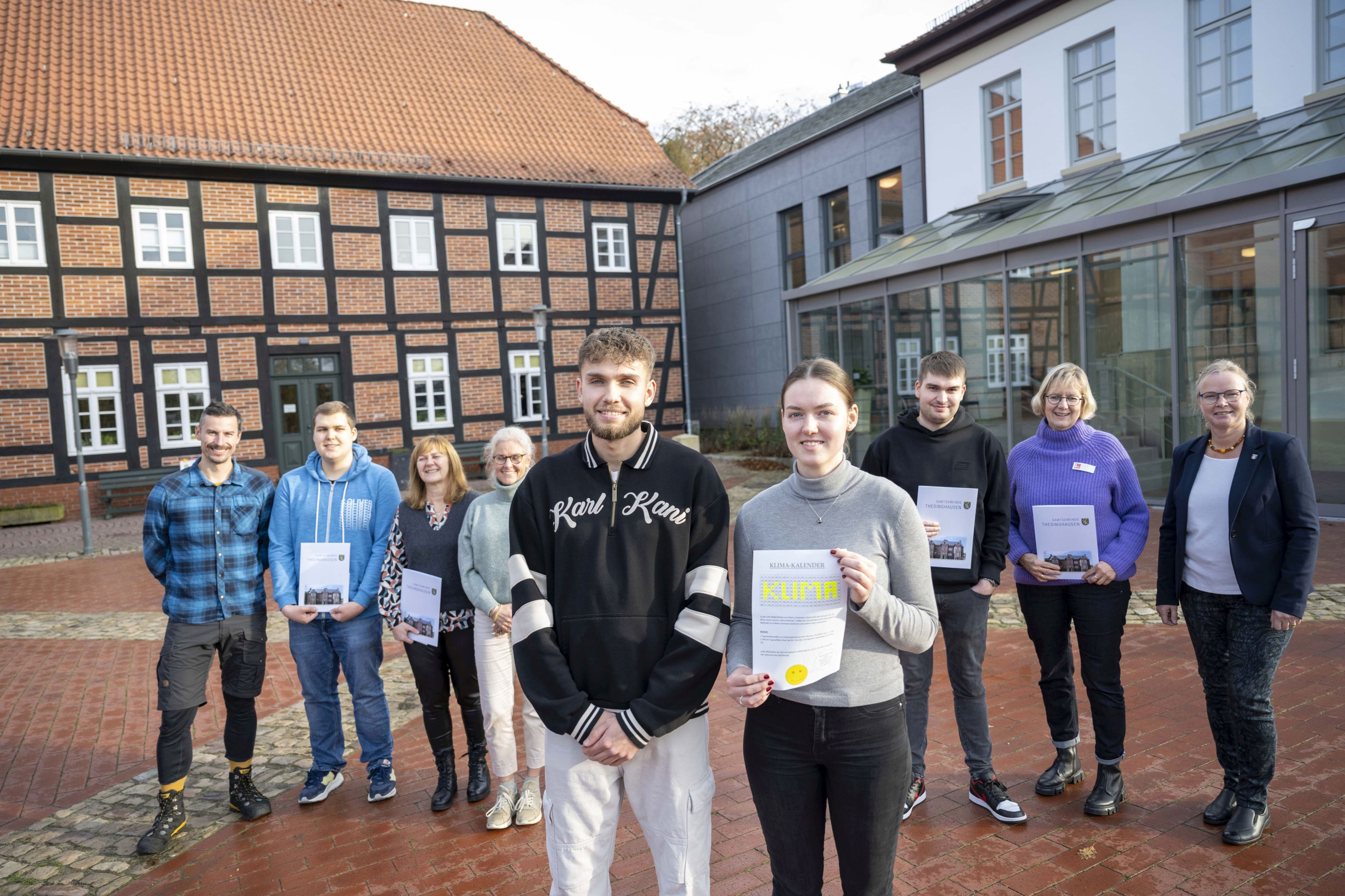 Abschlussbild der Urkundenübergabe in Thedinghausen. Vorne v.l.: Justin Hermann und Vanessa Paul, Auszubildende Thedinghausen. Hinten links: Hendrik Jechlitschek (kleVer). Hinten rechts: Samtgemeinde Bürgermeisterin Anke Fahrenholz. Dazwischen: Gewinner:innen der Klimachallenge. 